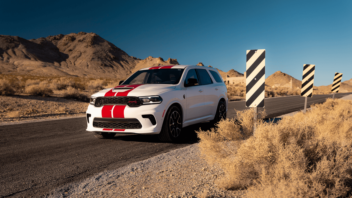 2026 Dodge Durango in Margate FL in white with bold red racing stripes, SRT hood scoop, and black alloy wheels on a desert highway — a stronger way to move through South Florida