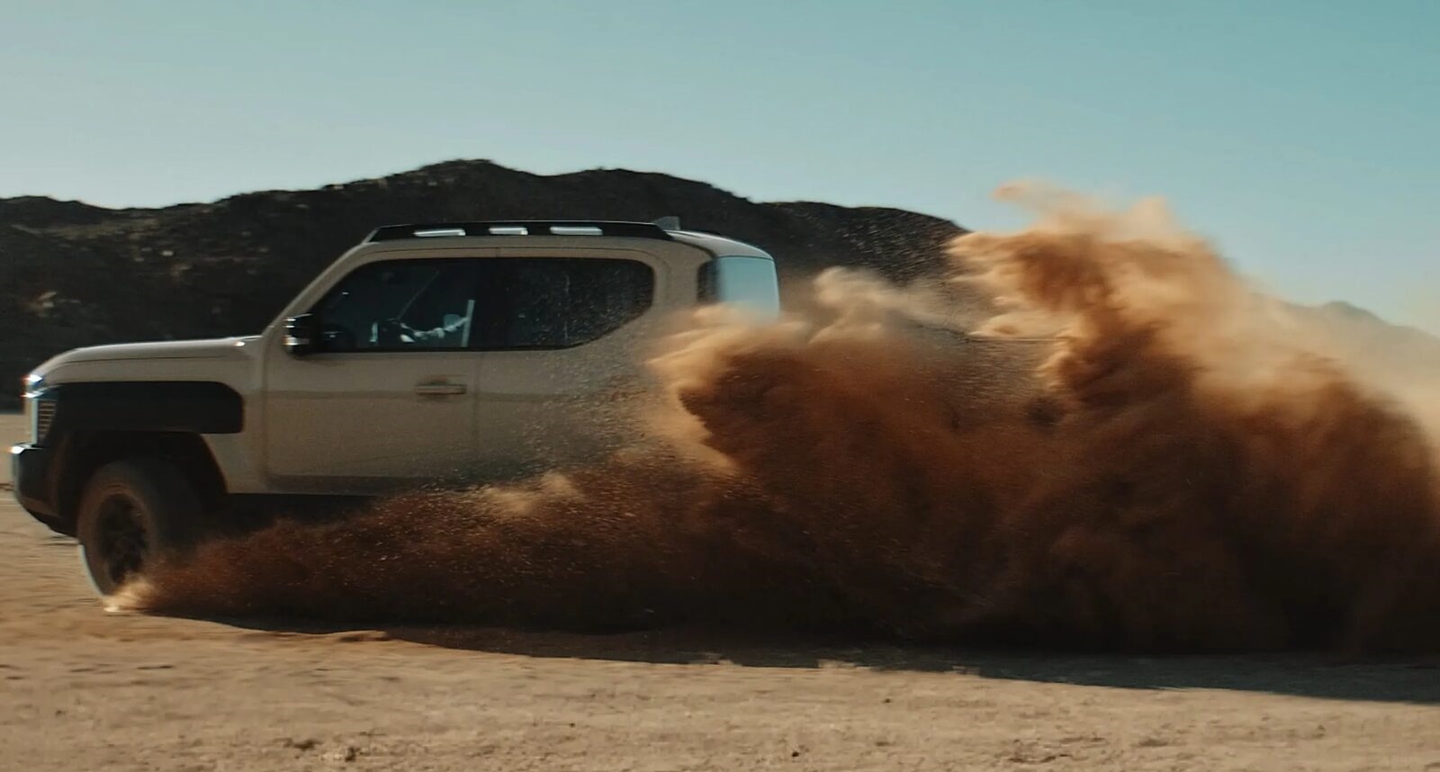 Kia Tasman pickup truck front view desert landscape