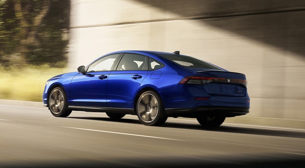 Rear of a blue 2026 Honda Accord Hybrid driving through a tunnel.