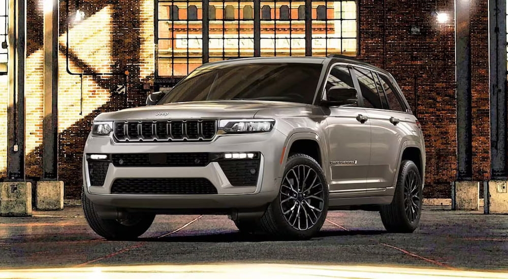 White 2026 Jeep Grand Cherokee parked in a warehouse.