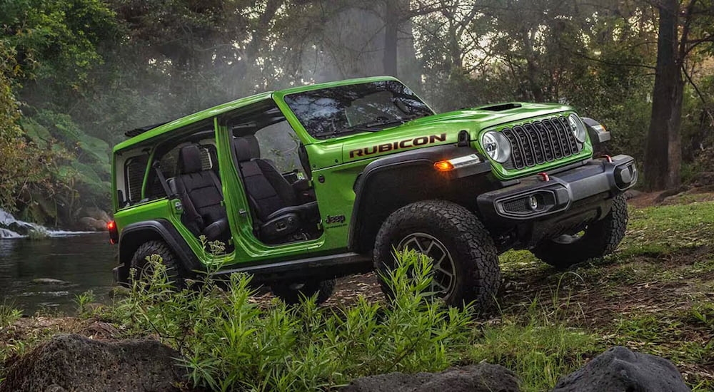 Green 2026 Jeep Wrangler driving in a forest.