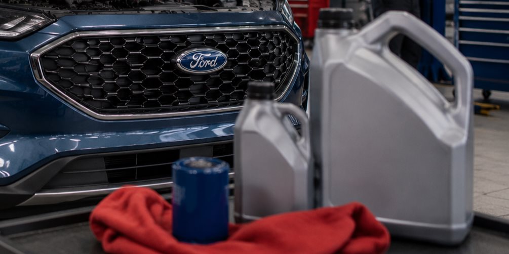 Ford service technician performing an oil change with a Motorcraft filter on a Ford in the Murgado Ford of Chicago service bay