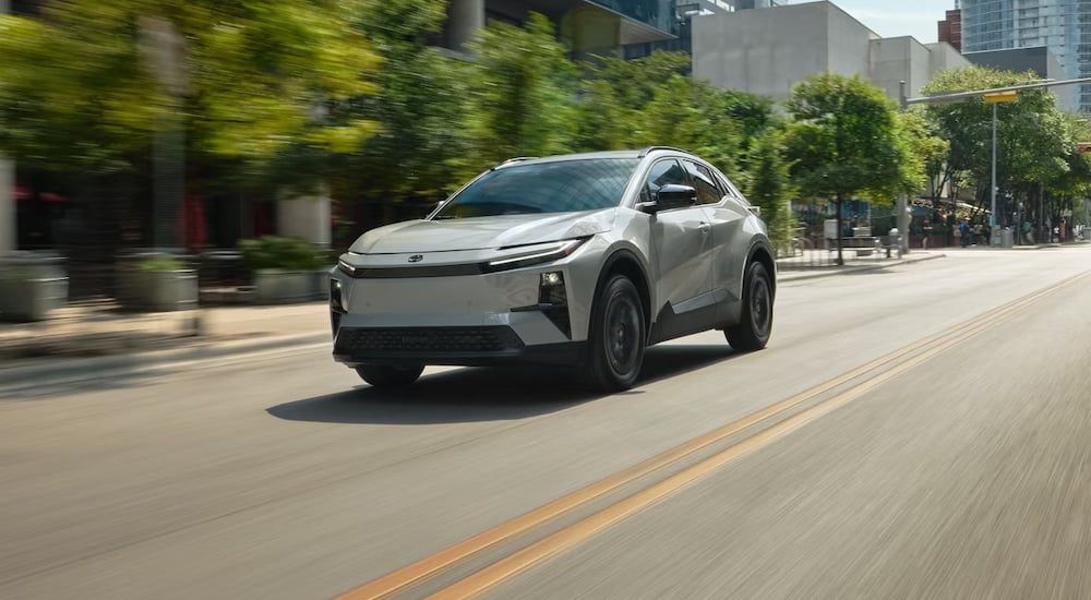 Grey 2026 Toyota C-HR driving down a city street.