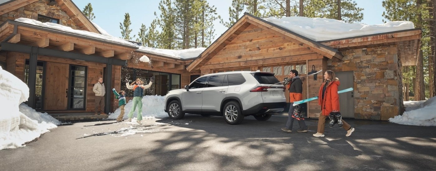 White 2026 Toyota Grand Highlander Platinum parked near a cabin