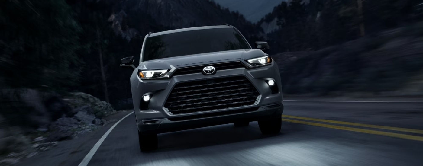 Grey 2026 Toyota Grand Highlander Hybrid Nightshade driving at night