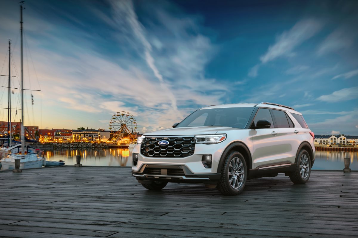White Ford Explorer SUV parked near a marina waterfront at sunset, highlighting the vehicle’s spacious and family-friendly design for summer road trips, vacations, and everyday travel.