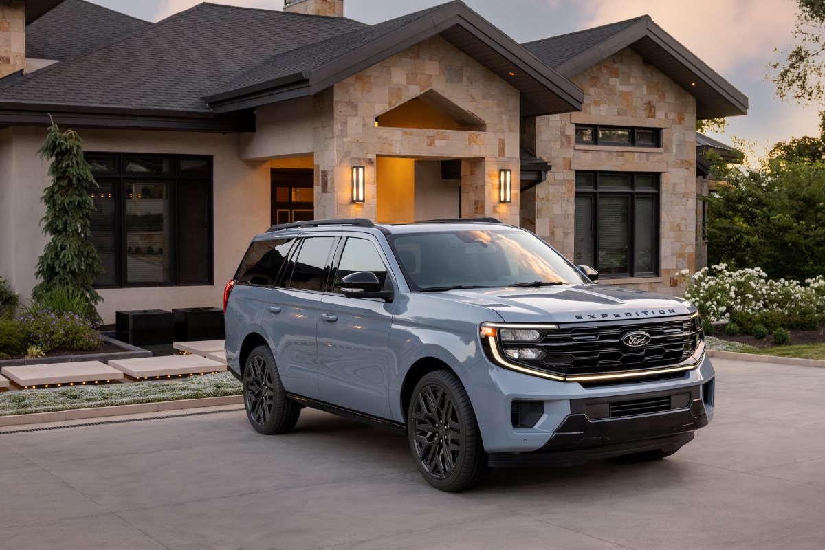 Gray Ford Expedition SUV parked in front of a modern luxury home at sunset, highlighting the vehicle’s spacious and family-friendly design for summer travel, cargo space, and comfortable road trips.