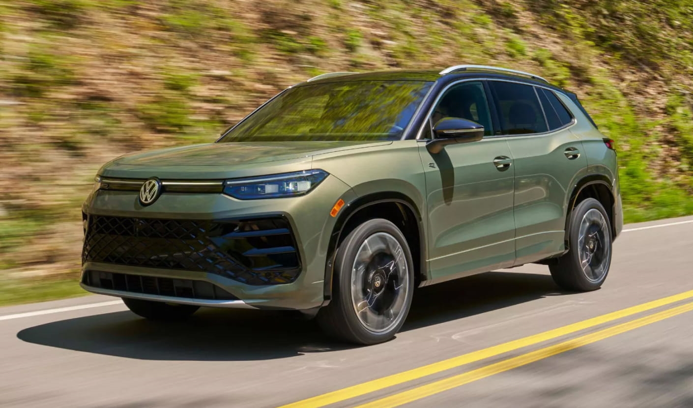 2026 Volkswagen Tiguan driving on a scenic road bordered by greenery