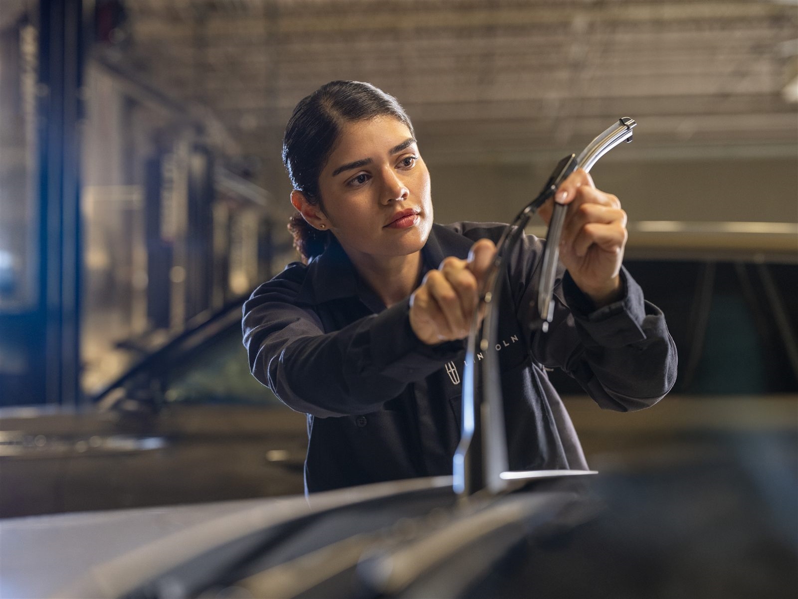 Technician replacing front wiper blade on Lincoln vehicle
