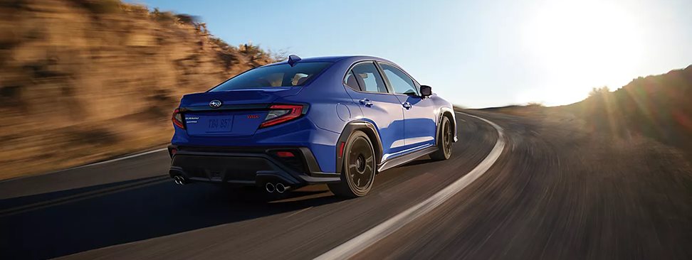 2026 Subaru WRX taking a sharp corner on a racetrack with track-tuned suspension keeping the car flat