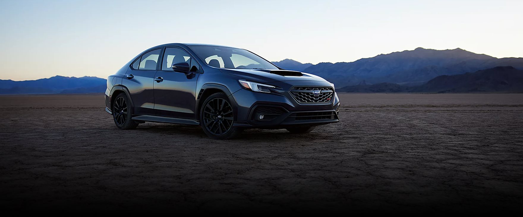 2026 Subaru WRX GT in motion on a winding road showcasing high-tech performance styling