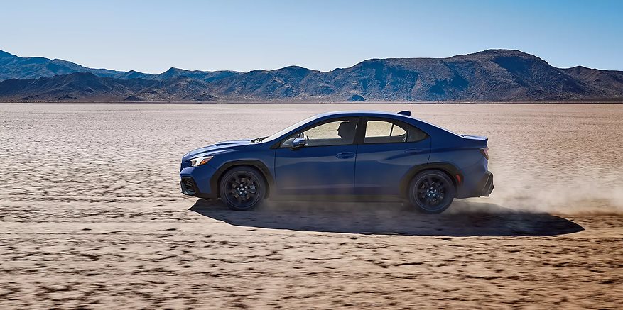 2026 Subaru WRX front three-quarter view highlighting aggressive front grille and bold hood scoop