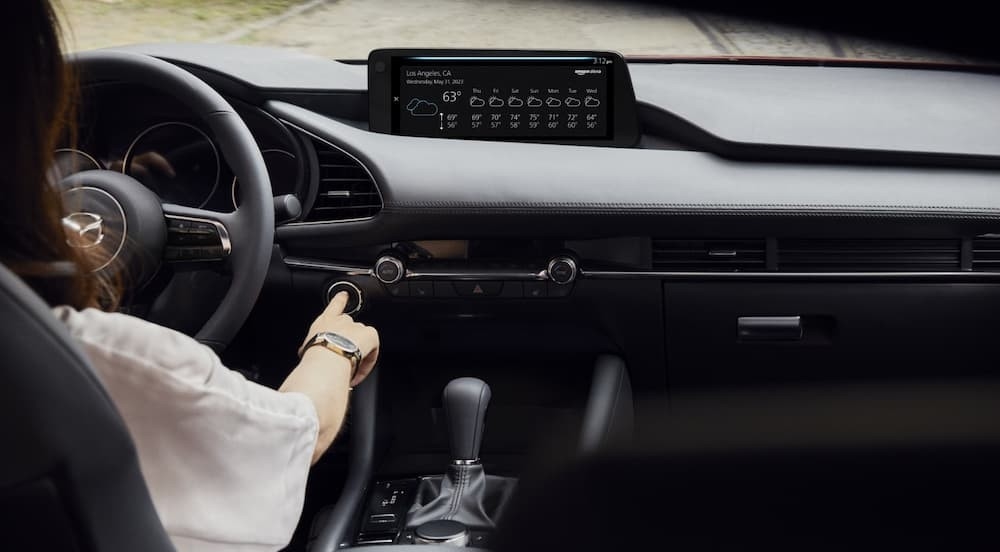 A person driving in a 2026 Mazda3 Sedan.