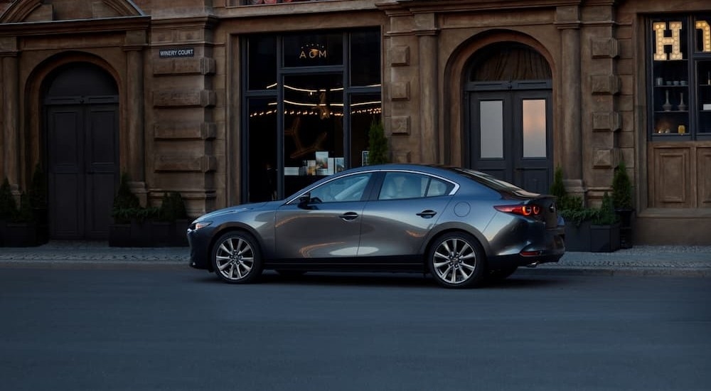 A gray 2026 Mazda3 Sedan parked in a city.