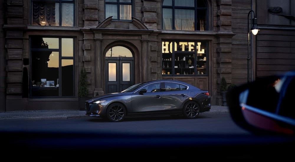 A gray 2026 Mazda3 Sedan parked near a hotel.