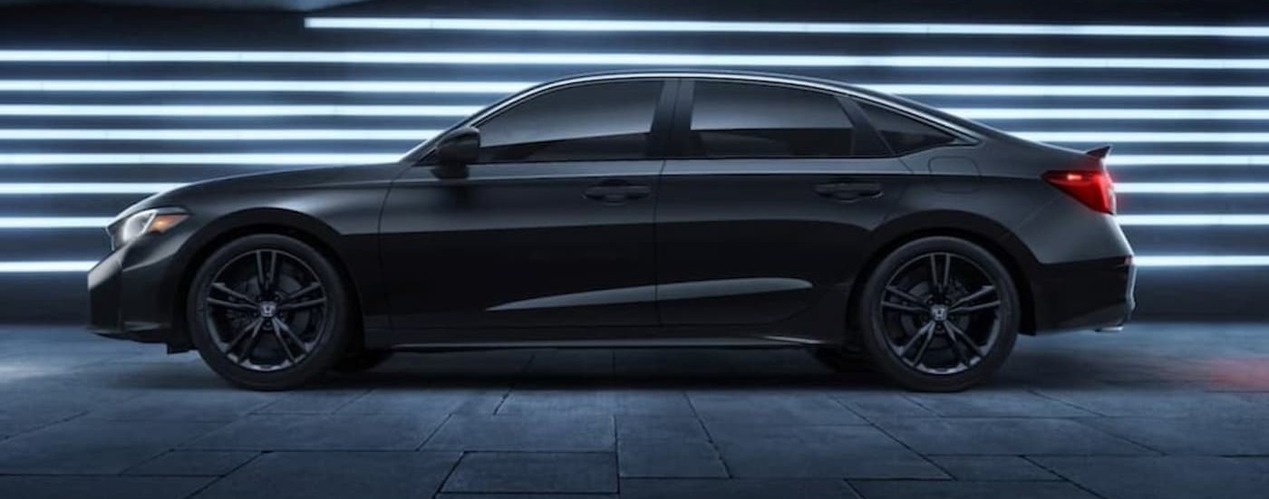 A black 2026 Honda Civic parked near a wall of lights.
