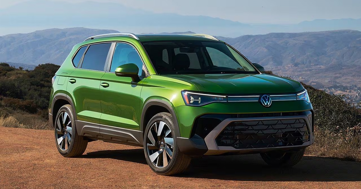 026 Volkswagen Taos compact SUV parked on a dirt overlook with mountain scenery.