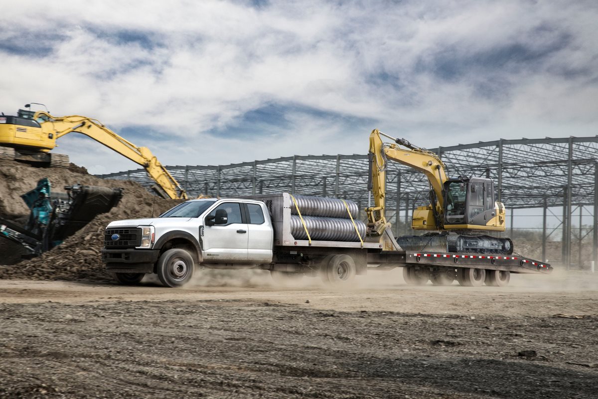 Ford Super Duty work truck transporting equipment at a construction site, highlighting the importance of reliable commercial vehicles for business operations.