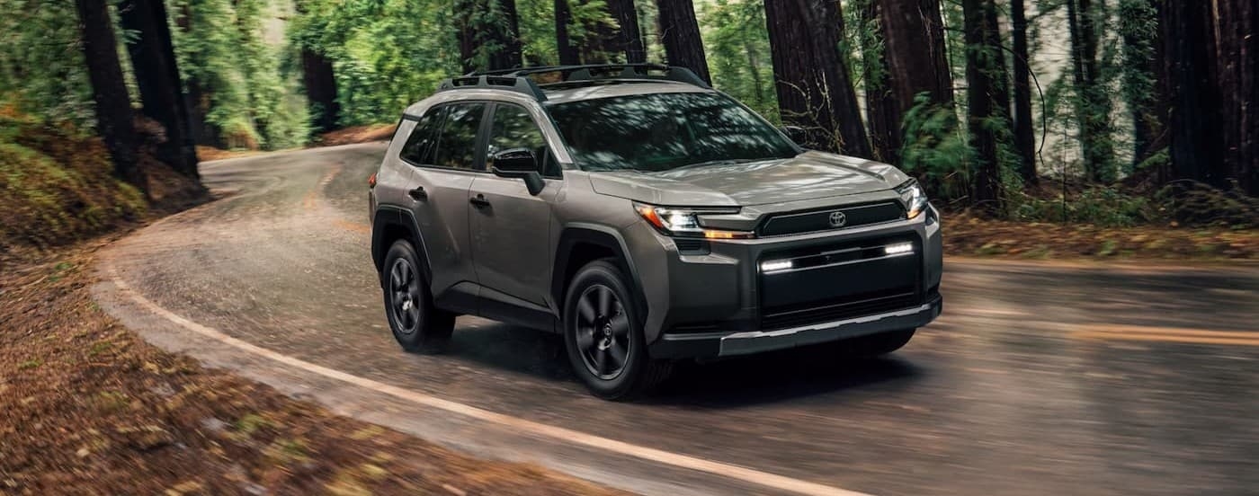 A gray 2026 Toyota RAV4 driving near trees.