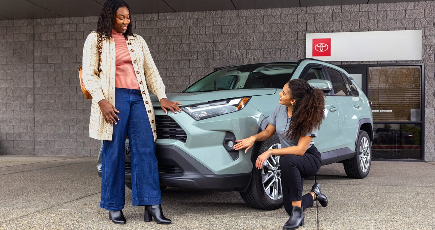 Toyota RAV4 XLE inspected by a specialist in front of a collision center.