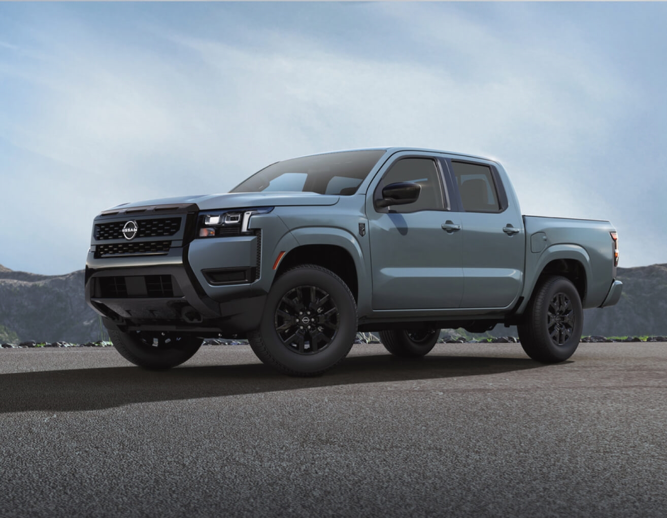 Nissan Frontier Dark Armour exterior shown  with a mountainous backdrop.