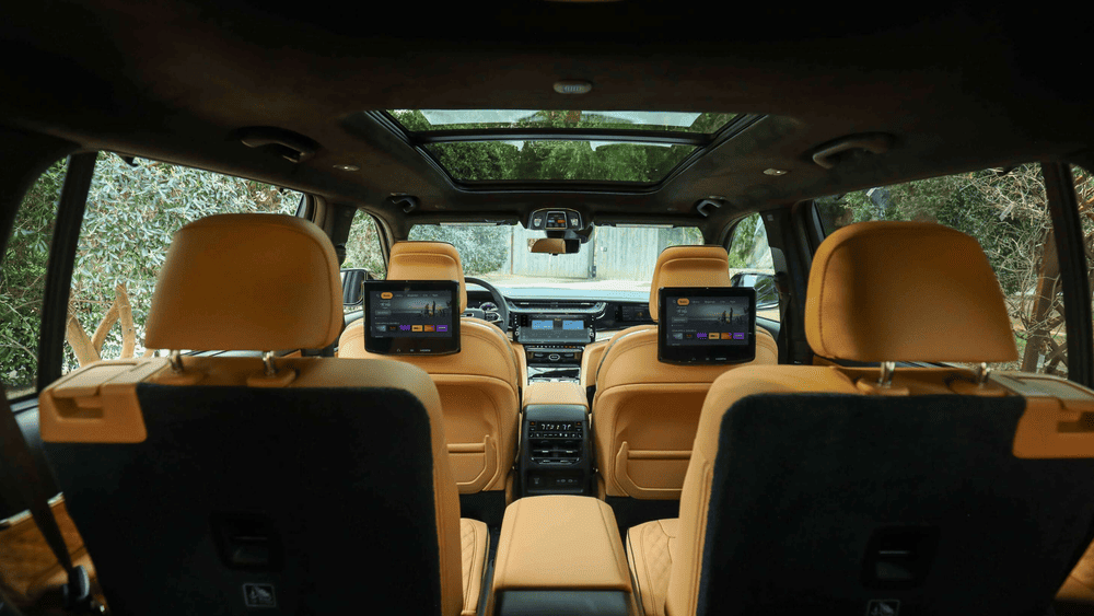 2026 Jeep Grand Cherokee L in Margate FL showing three-row tan leather seating, dual rear entertainment screens, panoramic sunroof, and second-row climate controls