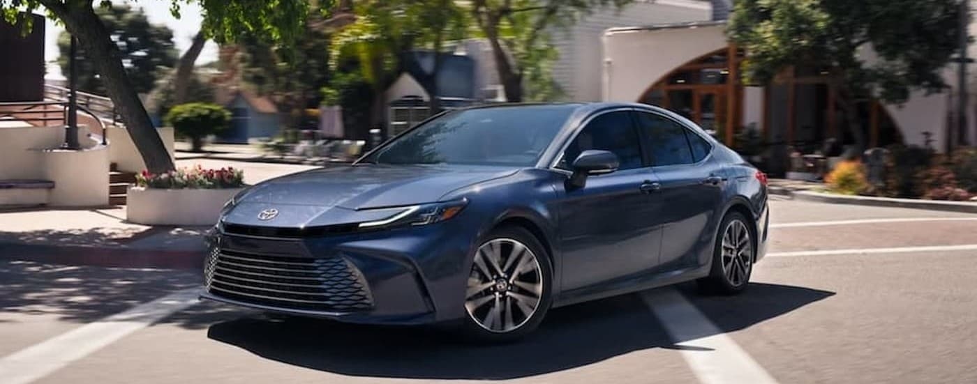 A blue 2026 Toyota Camry driving in a city.