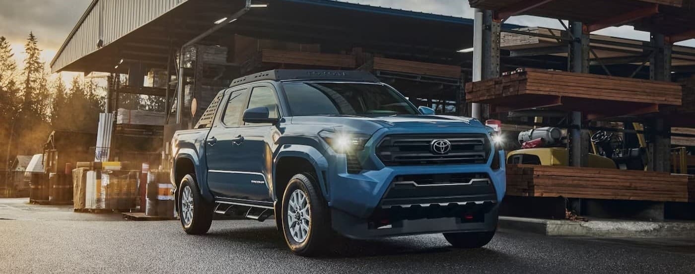 A blue 2026 Toyota Tacoma parked in a lumber yard.