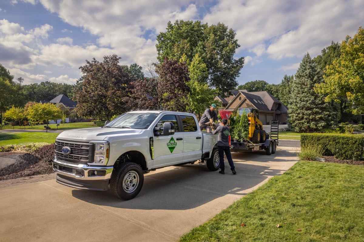 Ford F-250 work truck being used by a landscaping crew at a residential job site.