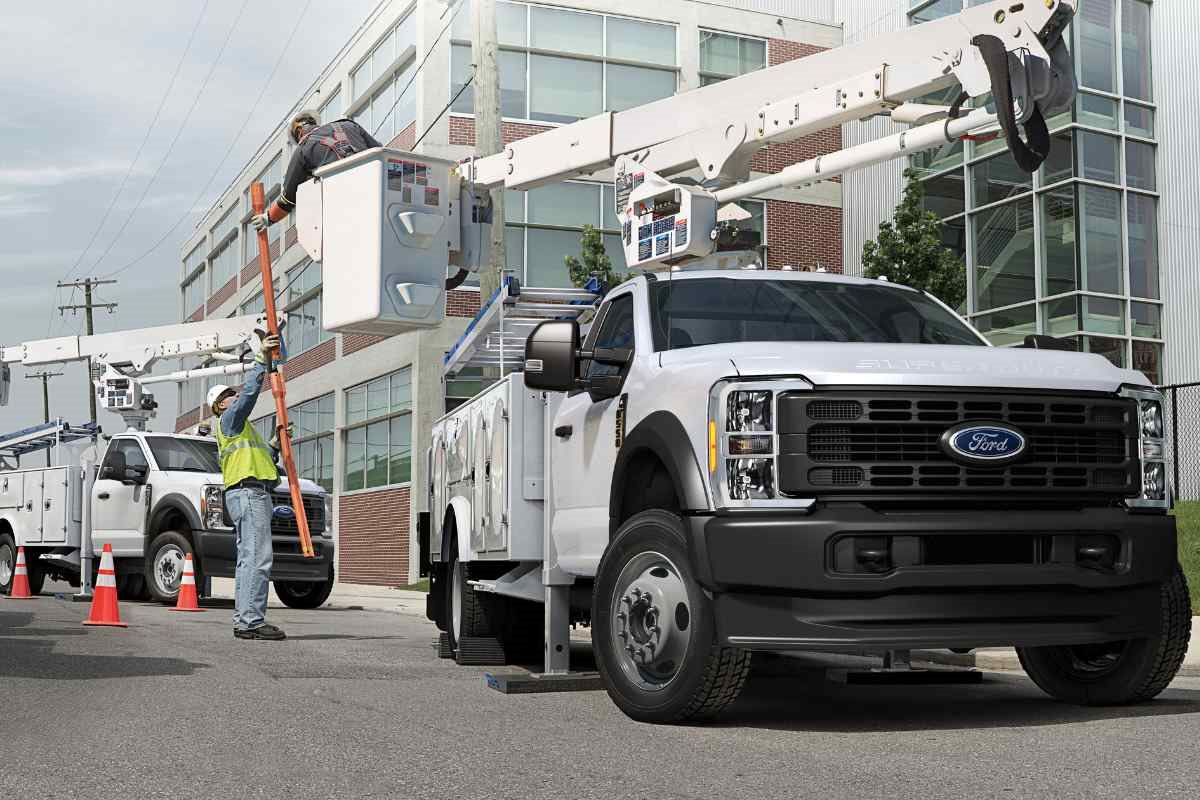 Ford Super Duty work trucks with service bodies and ladder racks parked at a commercial job site.