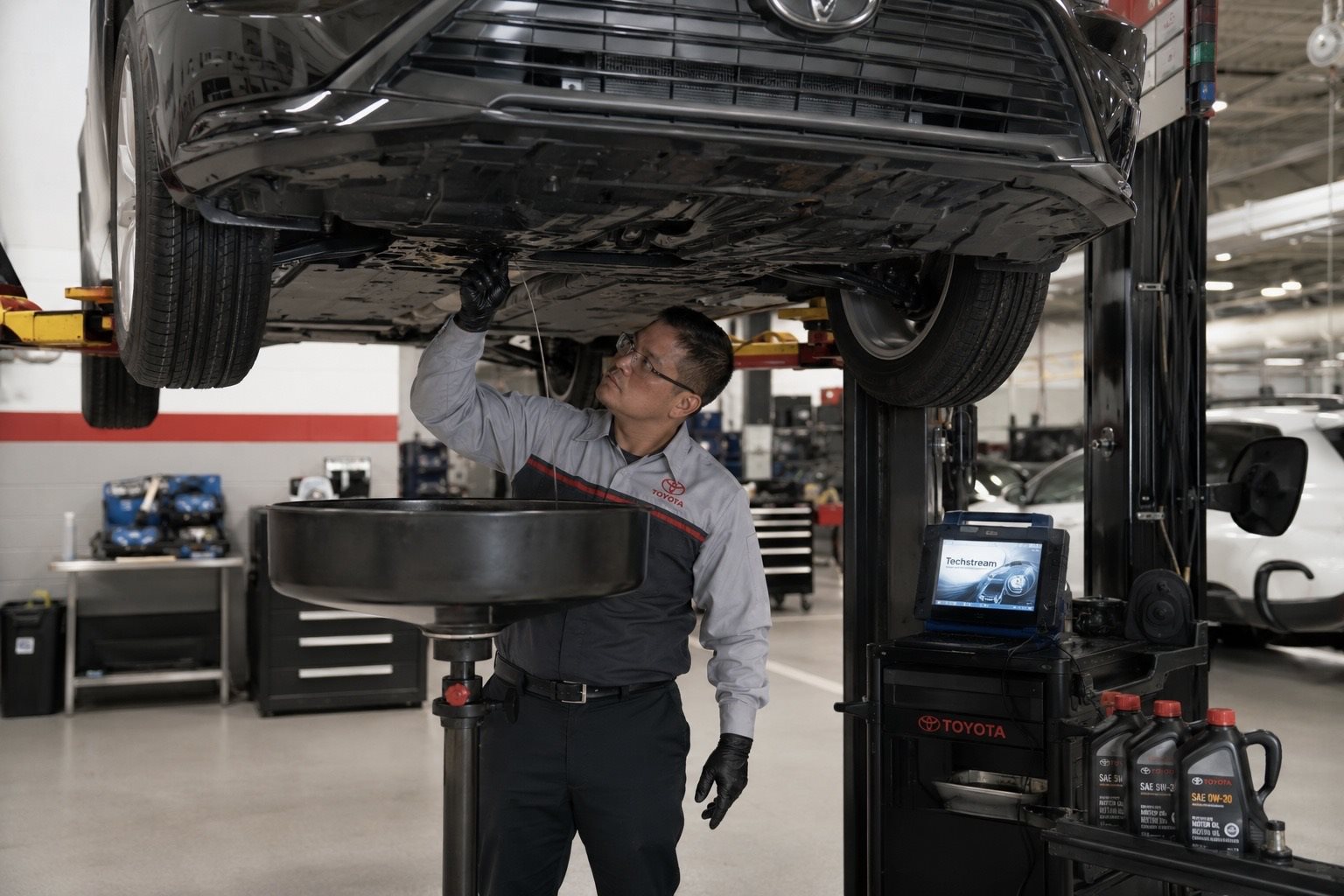 Toyota-trained technician performing synthetic oil change on a RAV4 at Toyota of Downtown Chicago service bay