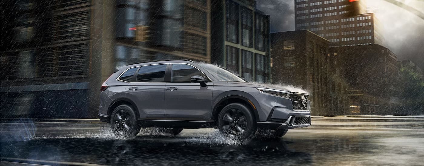 Grey 2026 Honda CR-V driving down a city street.