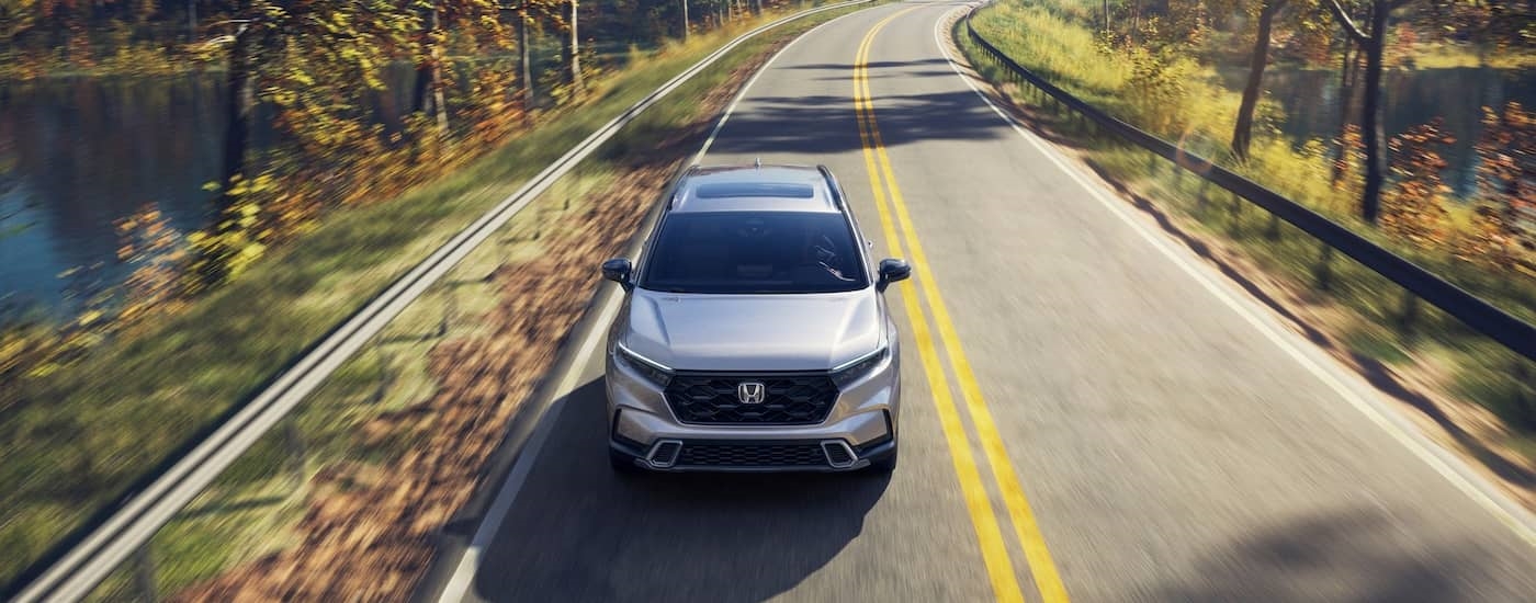 High view of a white 2026 Honda CR-V driving down an open road.