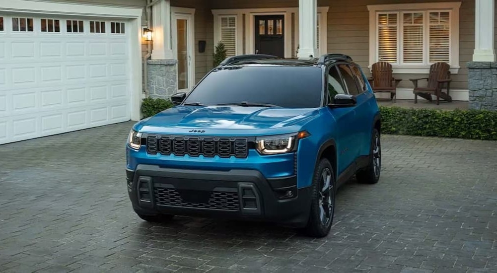 A blue 2026 Jeep Cherokee parked on a driveway.