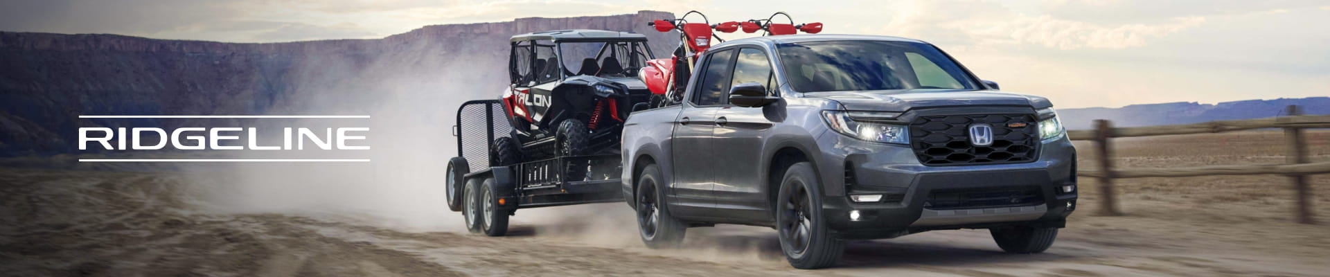 2026 Honda Ridgeline truck towing an off-road vehicle through a dusty desert landscape.