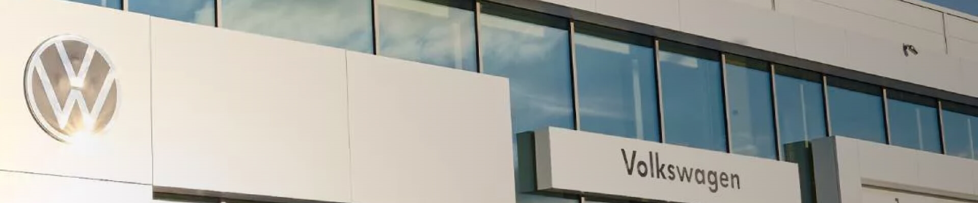 Volkswagen Dealership showcases its modern white facade and signature logo.