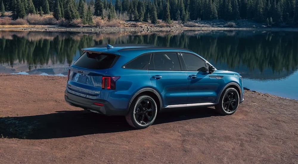 A blue 2026 Kia Sorento PHEV parked near water.