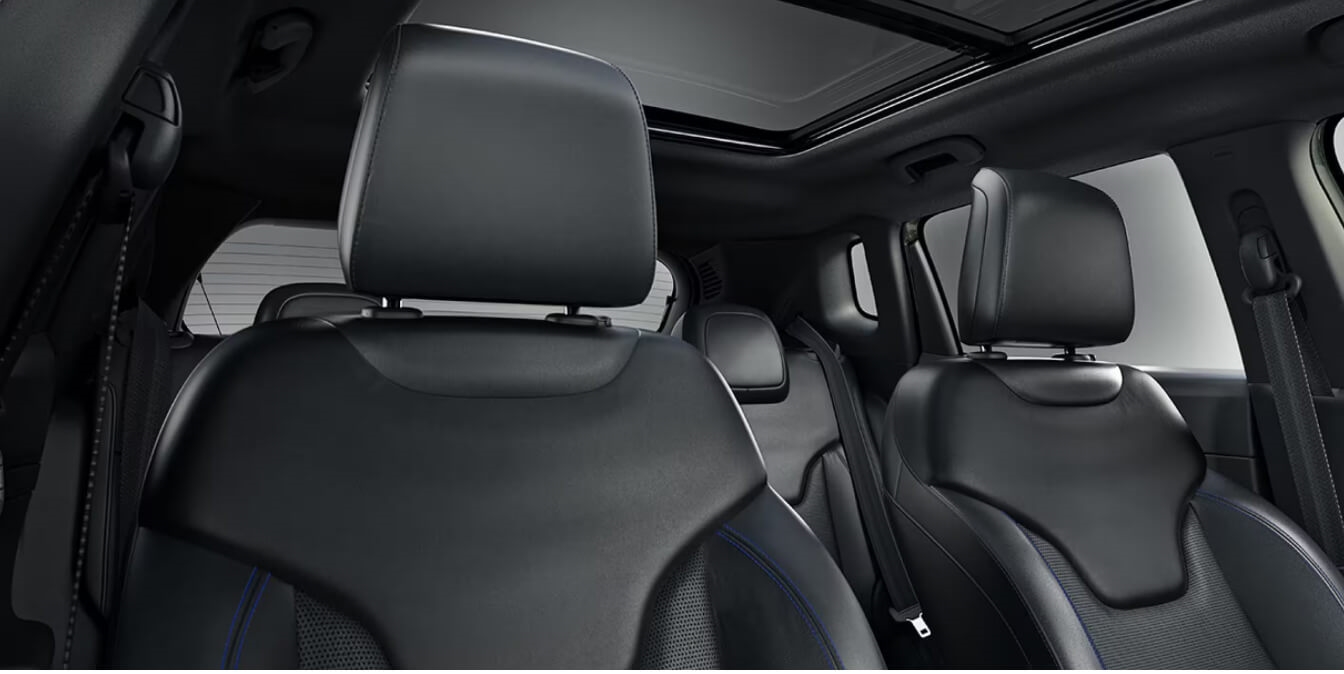 Jeep Compass displays detailed blue stitching on front bucket seats in a commercial studio.