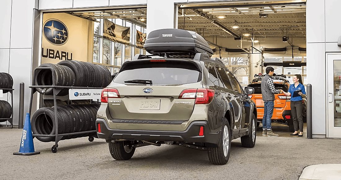 A Subaru Outback at the Findlay Subaru Prescott service drive, where an advisor meets an owner checking in.