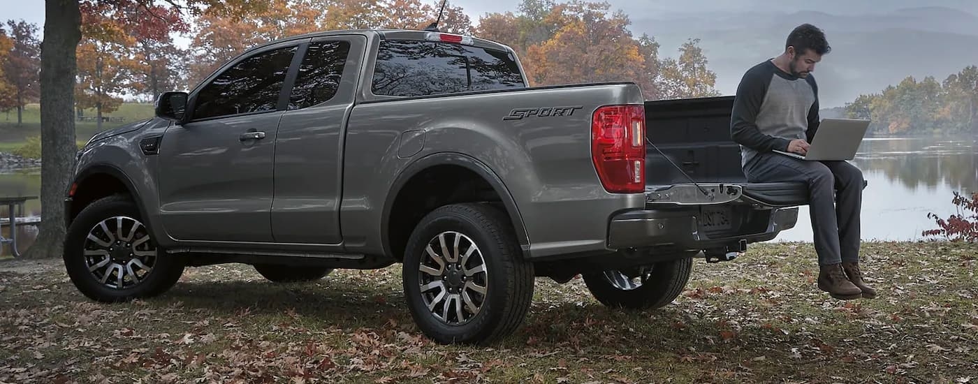 Person using a laptop in the bed of a grey 2022 Ford Ranger Sport