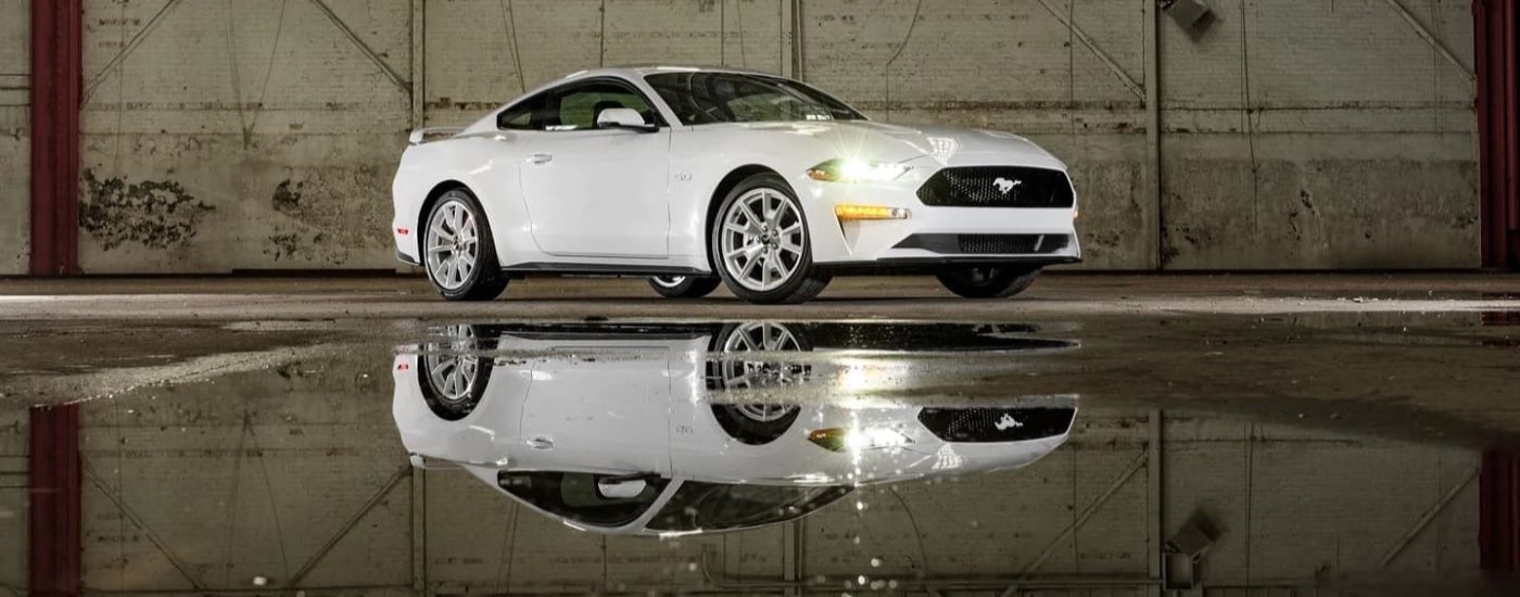 White 2023 Ford Mustang GT Ice White Edition near a puddle in a warehouse
