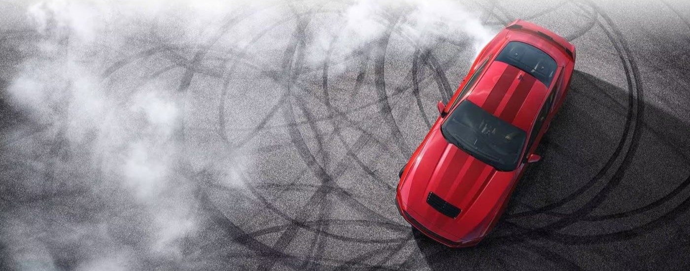 Red 2024 Ford Mustang doing donuts