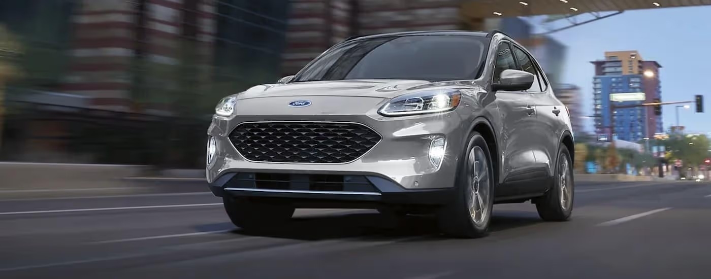 A silver 2021 Ford Escape is shown driving in a city.