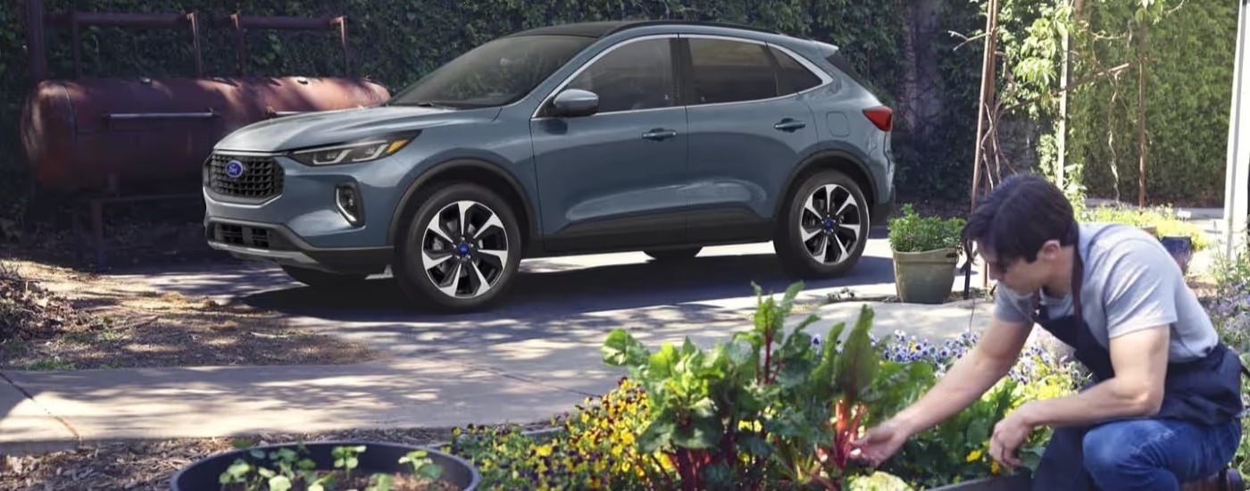 A blue 2023 Ford Escape Platinum is shown parked in a driveway