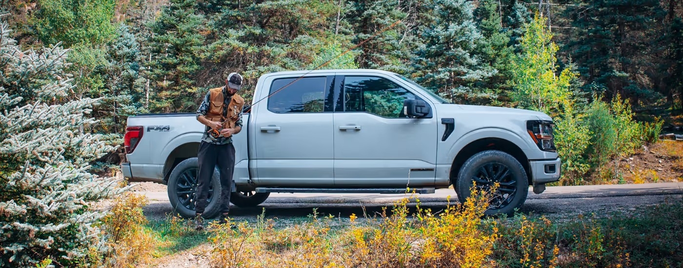 White 2025 Ford F-150 with a person setting up a fishing rod