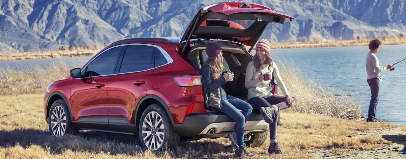 Red 2021 Ford Escape with two people sitting in the trunk