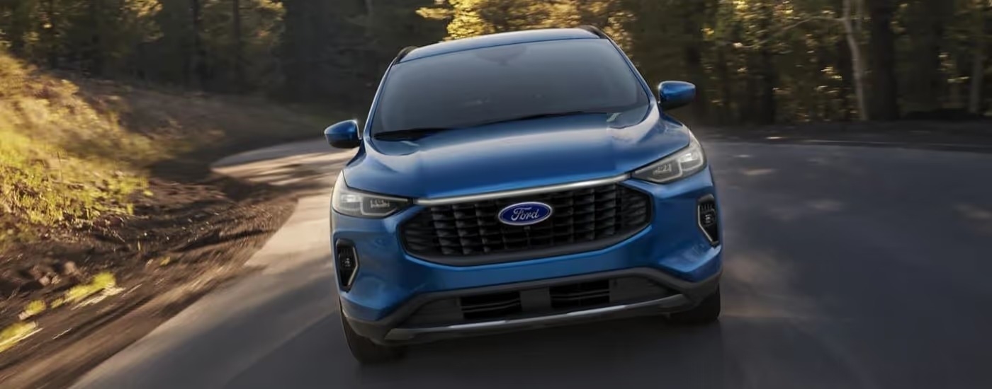 Blue 2023 Ford Escape driving down an empty road
