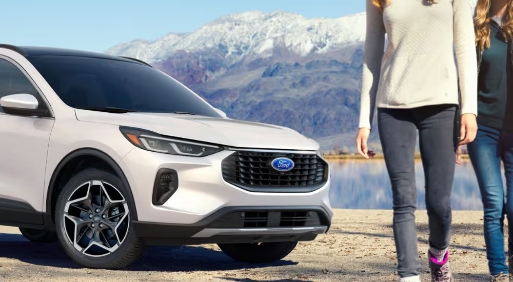 White 2026 Ford Escape with two people walking away from it near a lake.