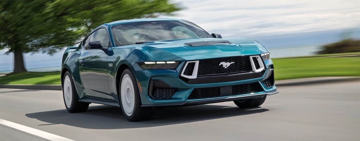 A green 2026 Ford Mustang GT Premium FX driving to a Ford dealer near Alpharetta.