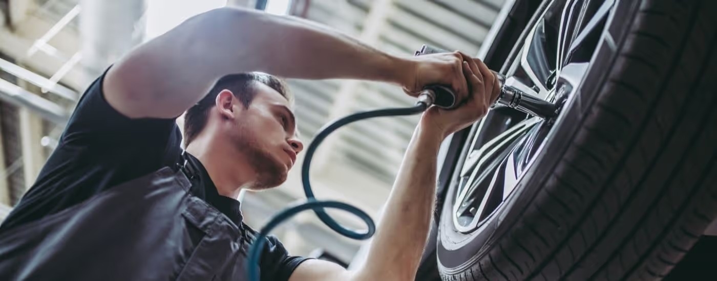 A mechanic is installing a wheel at a Ford service center near Marietta.